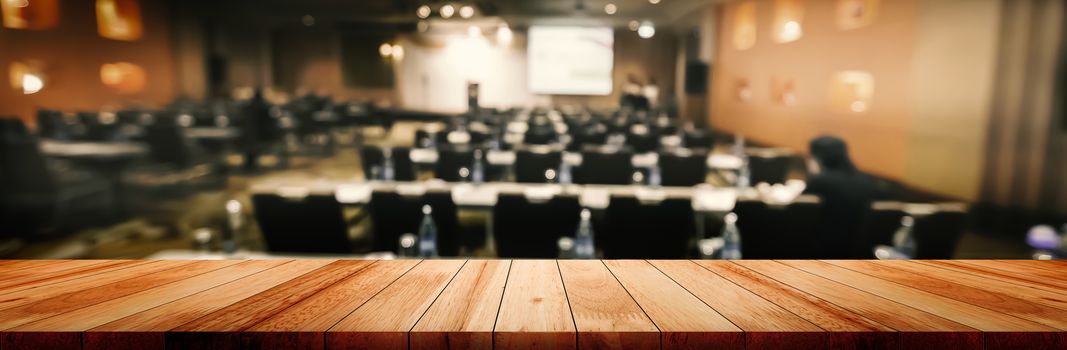 Panoramic empty clean wood counter table top on blur student study in classroom white light background for product education learning hall centre, Abstract Blurry wooden desk scene display or montage.
