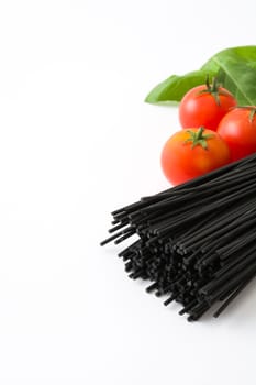 Black spaghetti with tomatoes and basil isolated on white background