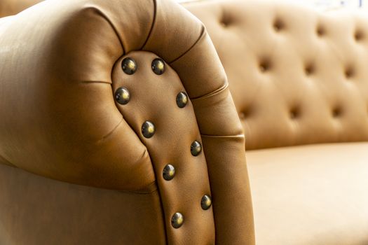 Close up of pins and buttons on a vintage style sofa. Buttoned vintage sofa up close.