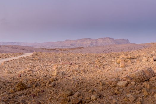 Blue hour view with a footpath and Mount Ardon, in Makhtesh (crater) Ramon, the Negev Desert, Southern Israel