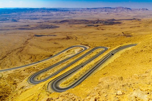 View of cliffs, landscape, and hairpinned road in Makhtesh (crater) Ramon, the Negev Desert, Southern Israel