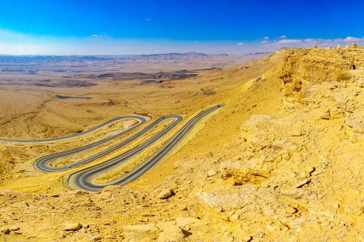 View of cliffs, landscape, and hairpinned road in Makhtesh (crater) Ramon, the Negev Desert, Southern Israel