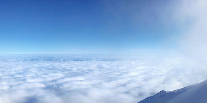 Temperature inversion forming sea of clouds seen from above, high in mountains. Lomnicke sedlo ski resort. Slovakia