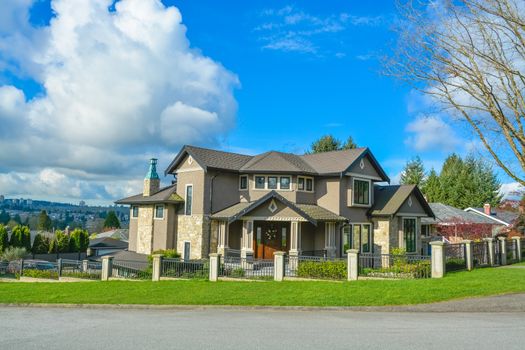 Luxury residential house with great view on Vancouver. Family house with green lawn and metal fence in front