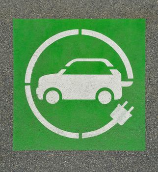 EV - electric vehicle charging station sign on asphalt. 'E' sign on asphalt texture