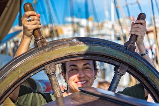 Young girl beside a ship steering