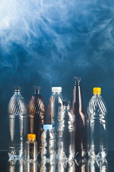 variety of plastic bottles in smoke, pollution concept