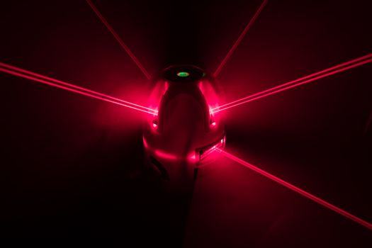 laser level tool red light beams, abstract background