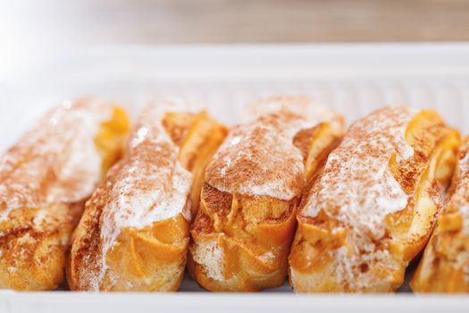 eclairs pastry on a plastic tray, close-up view