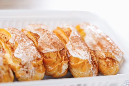 eclairs pastry on a plastic tray, close-up view