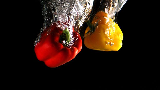 Colorful fresh vegetable cleaning by drop in to water splash and black background.