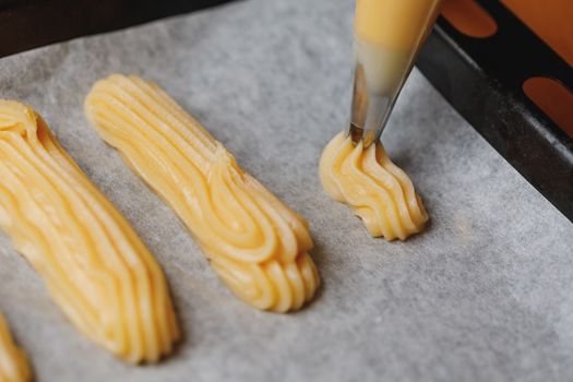 raw eclairs choux pastry on the baking tray