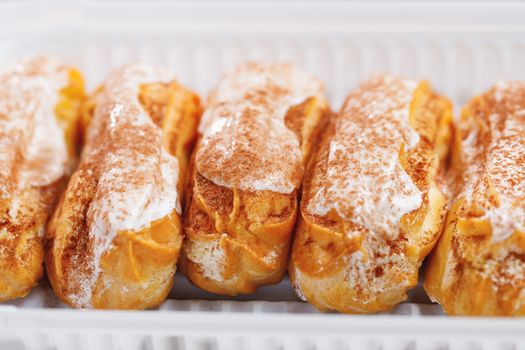 eclairs pastry on a plastic tray, close-up view