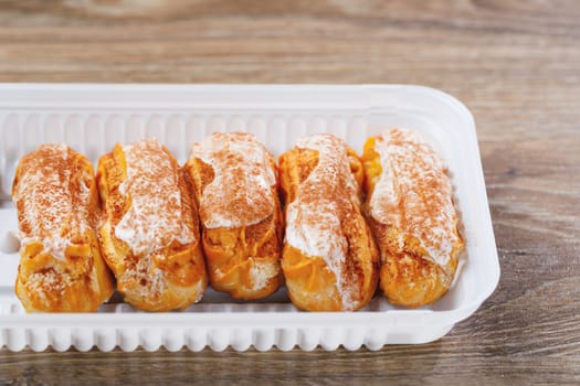 eclairs pastry in a plastic box, close-up view