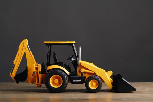 backhoe tractor toy, gray background