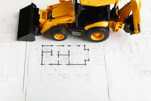 tractor toy on housing construction blueprint