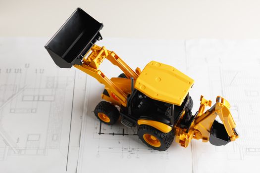 tractor toy on housing construction blueprint