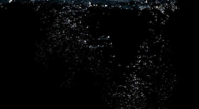 Soda water liquid splashing bubbles drop in black background represent sparkling and refreshing