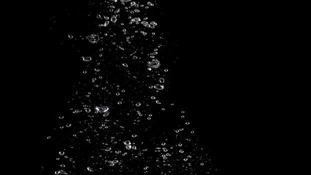 Soda water bubbles splashing and floating drop in black background represent sparkling and refreshing