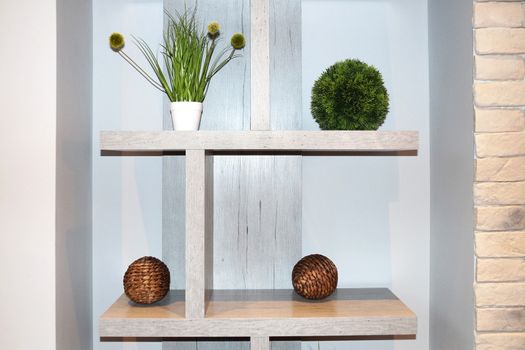 white interior shelf with decorative balls and potted plants.