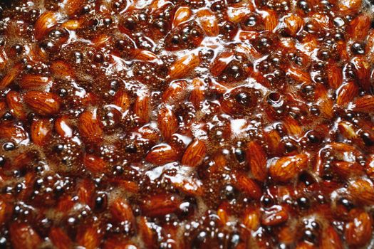 roasted almonds with cinnamon sugar cooking process, top view close-up