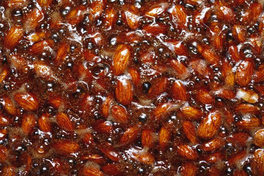 roasted almonds with cinnamon sugar cooking process, top view close-up