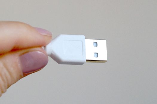 white usb cable in hand close-up