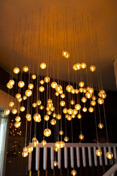 Stylish rich decor of the room is a chandelier made of many glowing balls.