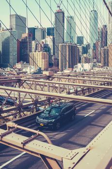 A Car Speeding Across Brooklyn Bridge With The Manhattan Skyline In The Background