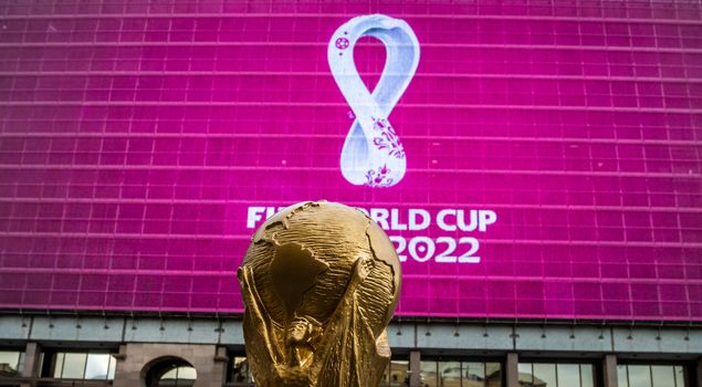 4 September 2019, Moscow, Russia. Copy of world cup trophy on background logo of the FIFA world Cup 2022, which will be held in Qatar, on a giant screen in the city center.