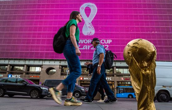 4 September 2019, Moscow, Russia. Copy of world cup trophy on background logo of the FIFA world Cup 2022, which will be held in Qatar, on a giant screen in the city center.