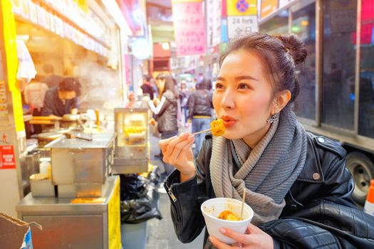 Chinese Asian young female model eating Chinese Steamed Dumpling on Street in Hong Kong