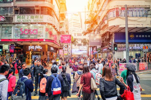 HONG KONG - March 13 2017: People walking across Road, Causeway Bay in front of a big department store at Daylight. Hong Kong March 13, 2017