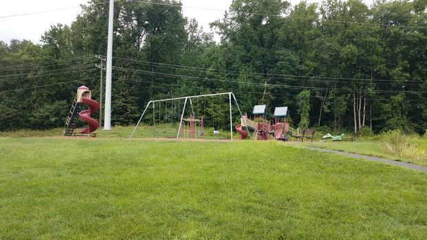 playground or park with slides and swingset and grass