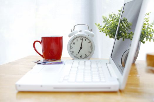 coffee cup with alarm clock Placed on the desk with a laptop