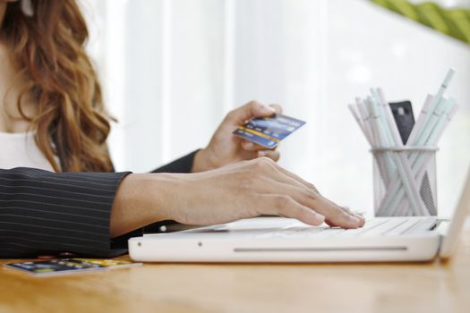 business woman sitting on a desk using a laptop computer