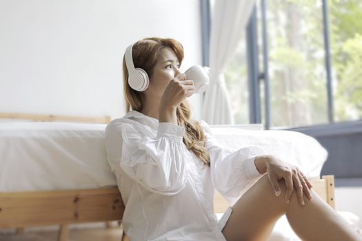 beautiful woman sitting in the bedroom with a cup of coffee