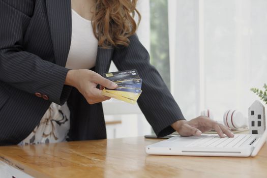 Business women shopping online with computer in hand carry credit card