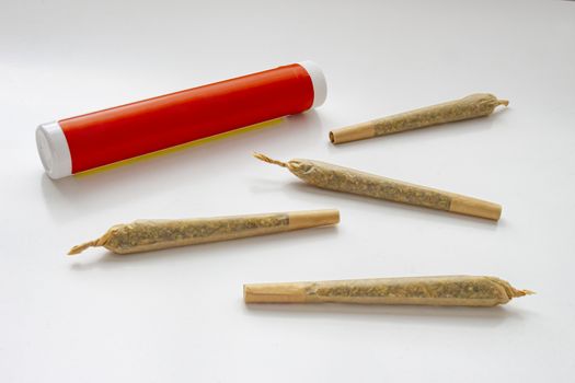 A Cannabis white and red plastic packaging container for Prerolls or Joints with pre-rolls cannabis joints around and a on a white background