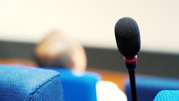 Mini microphone speaker in conference hall for speech in business seminar or organisation training or study and lecture and blurry images background.