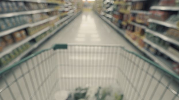 Blurry images of supermarket cart from people POV or point of view angle and shopping in the big hypermarket of Bangkok Thailand.