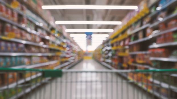 Blurry images of supermarket cart from people POV or point of view angle and shopping in the big hypermarket of Bangkok Thailand.