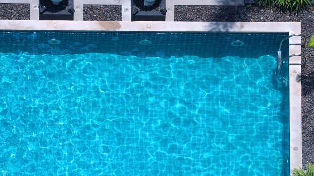 Bird eyes view images of hotel swimming pool salt system not clorine which have blue clear color water and good for health and relaxing in summer vacation day on Bangkok Thailand