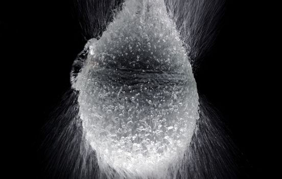 Water balloon exploding or splashing which represent power of refreshing or freshness for viewer and blasted by pencil in hand on black background in the studio.