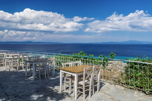 Restaurant outdoor seating area above the sea without customers in Kallithea, Kassandra peninsula.