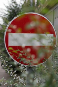 A sign prohibiting access hidden by vegetation.