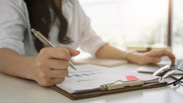 Business woman investment consultant analyzing company annual financial report balance sheet statement working with documents graphs. Concept picture of business, market, office, tax.