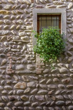 A planter at the window, surrounded by a stone wall.