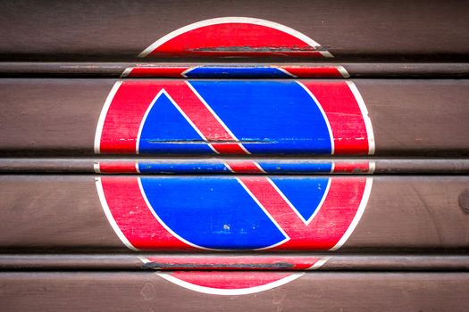 A symbol of parking ban posted on a gate.