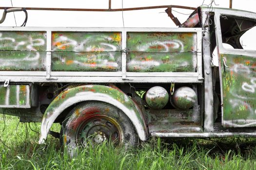 An old abandoned pickup truck, painted with bright colors.